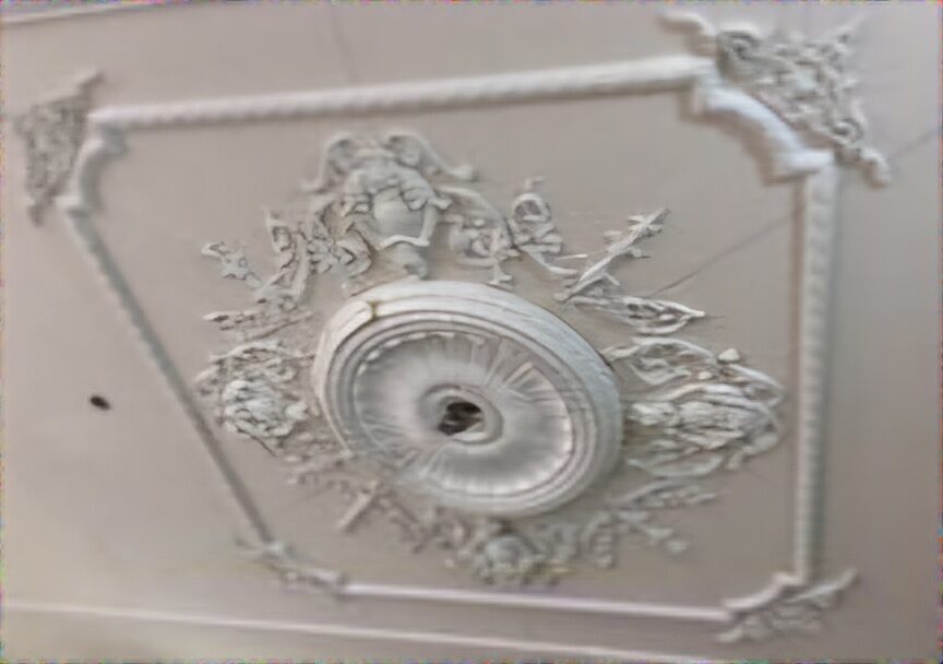 Handcrafted decorative ceiling rose set within a moulded ceiling border