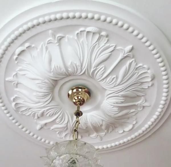 Ornate ceiling rose installed with brass ceiling fitting