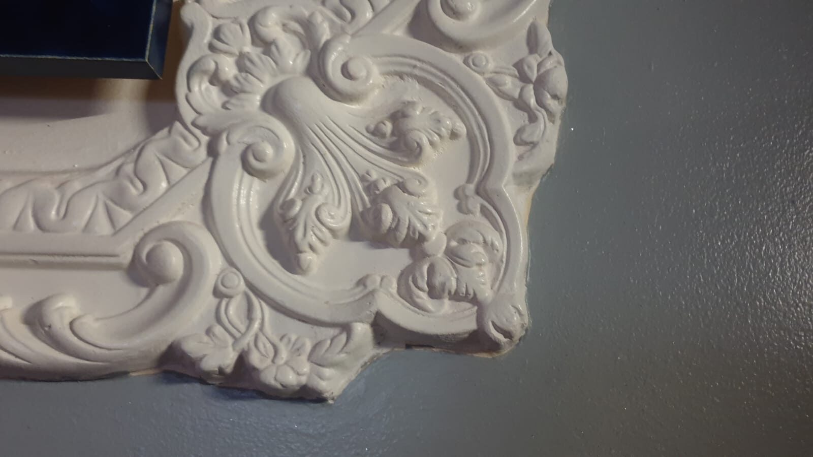 Close-up of a hand-finished decorative ceiling rose corner, unpainted plaster showing hand-tooled detail